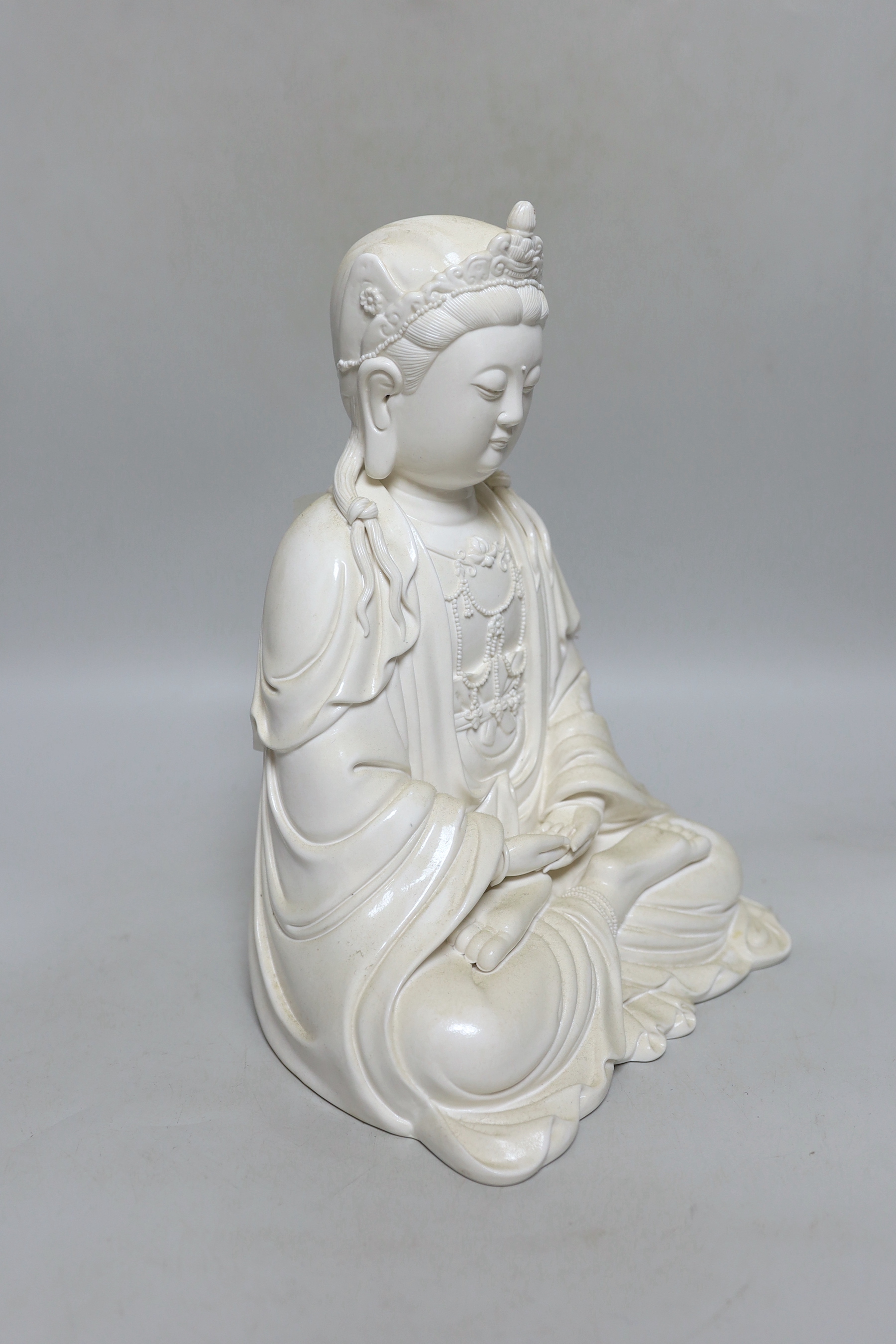 A Chinese blanc de chine seated figure of Guanyin, 29cm high